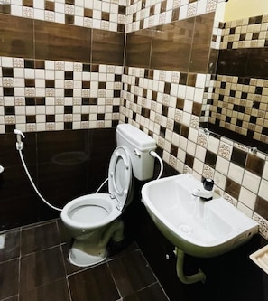 A bathroom with a toilet, sink, and tiled walls.