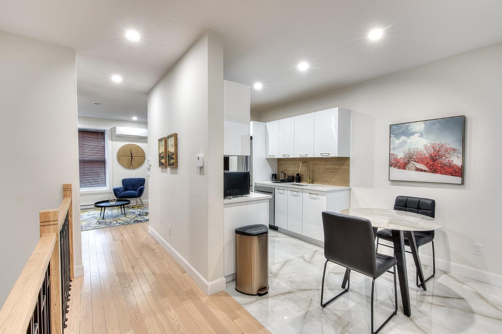 A modern kitchen with white cabinets, a black countertop, and a stainless steel sink.