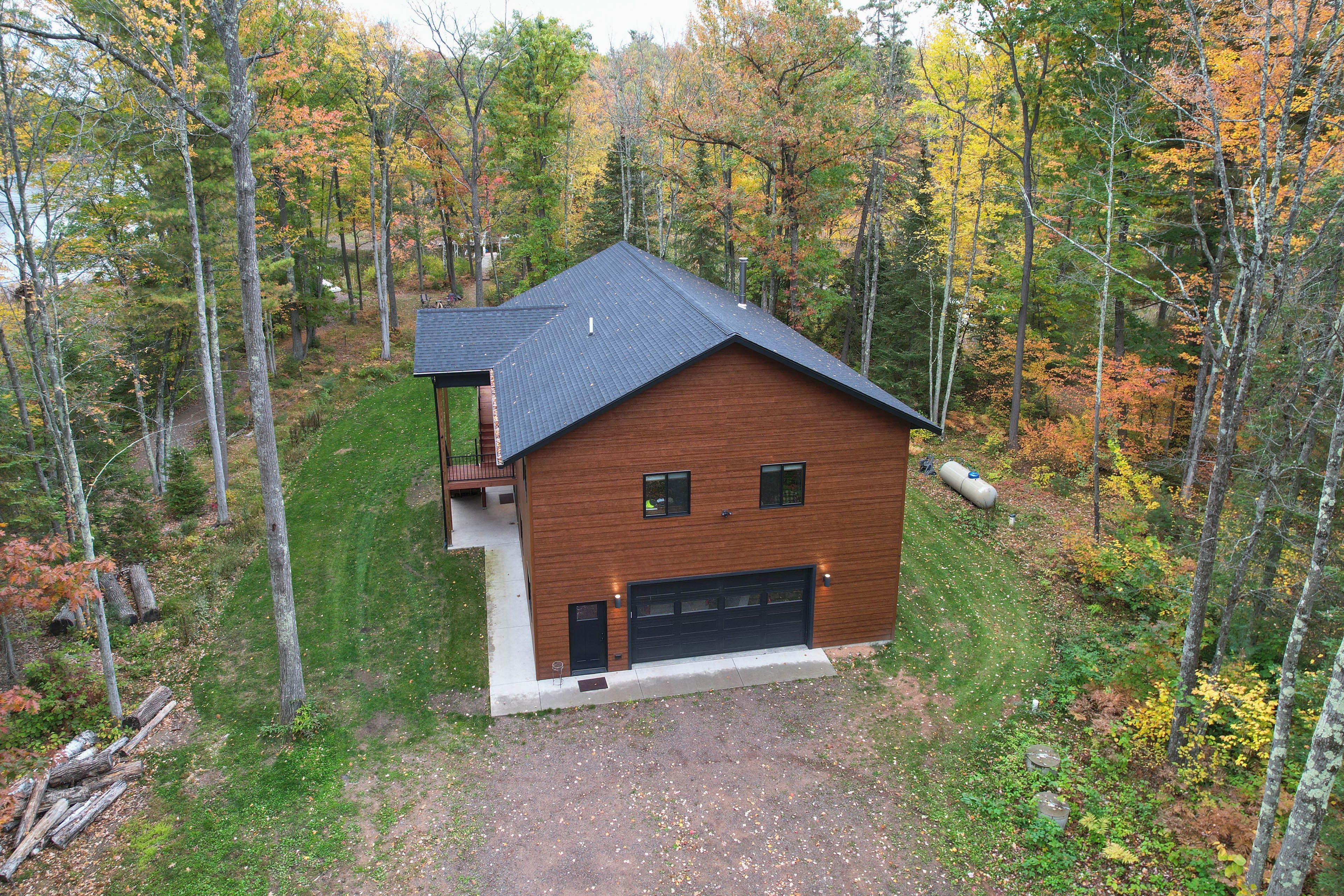 A two-story house with a dark roof, a garage, and a small balcony.