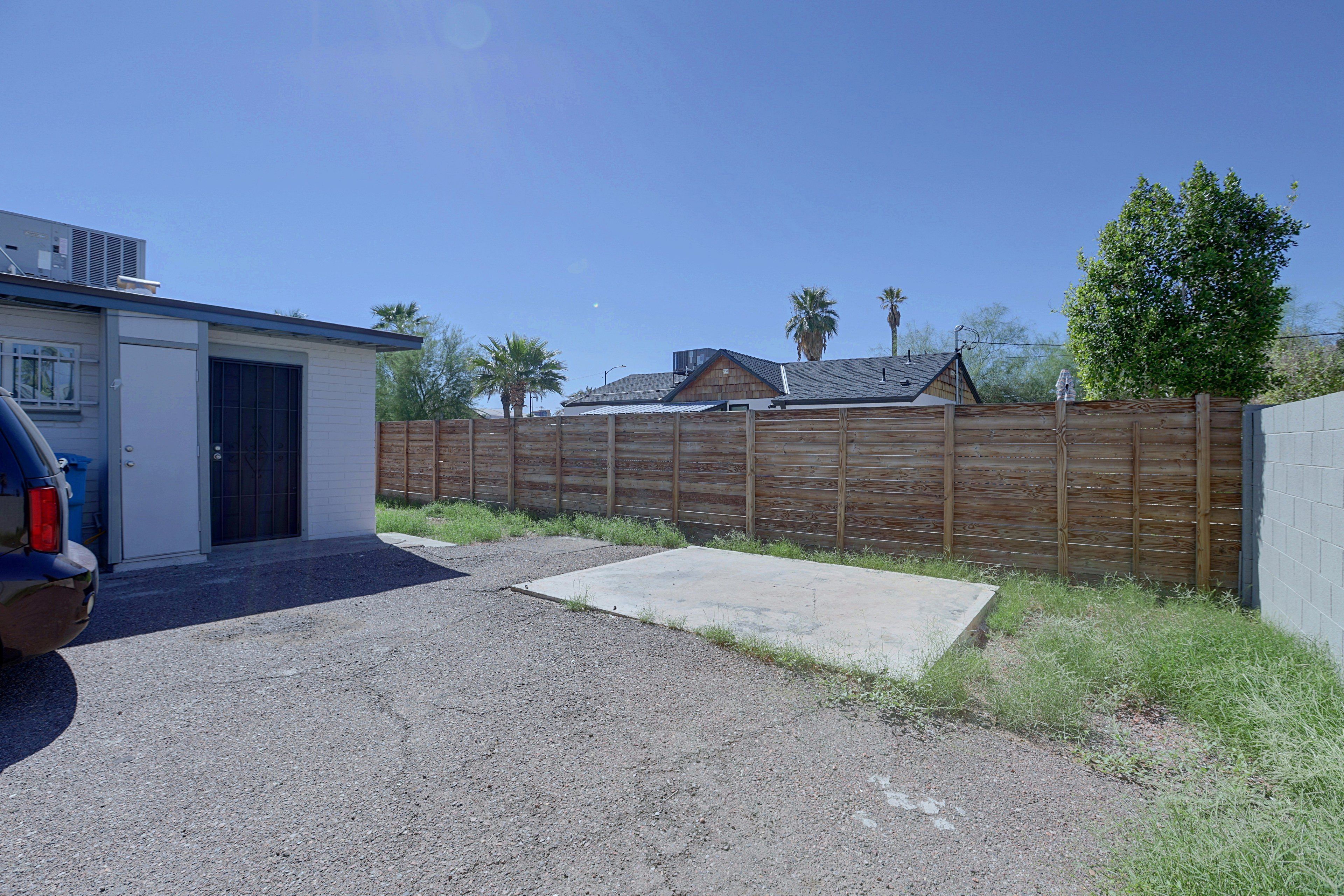 A residential property with a garage, a fenced backyard, and a clear sky.