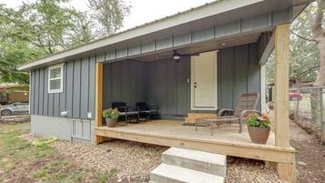 A small house with a porch, a door, and two chairs.