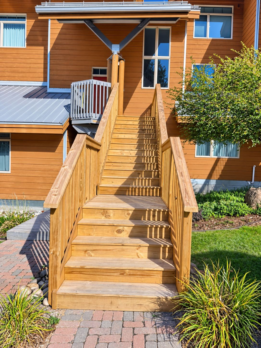 A wooden staircase leading to a house with a balcony.