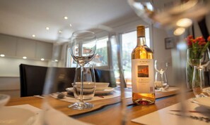 Ein Esstisch mit einer Weinflasche, Gläsern und Tellern, der an ein Restaurant erinnert.