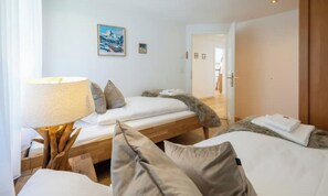 Ein Hotelzimmer mit Bett, Nachttisch mit Lampe, einem Fellwurf und einem Bild an der Wand.