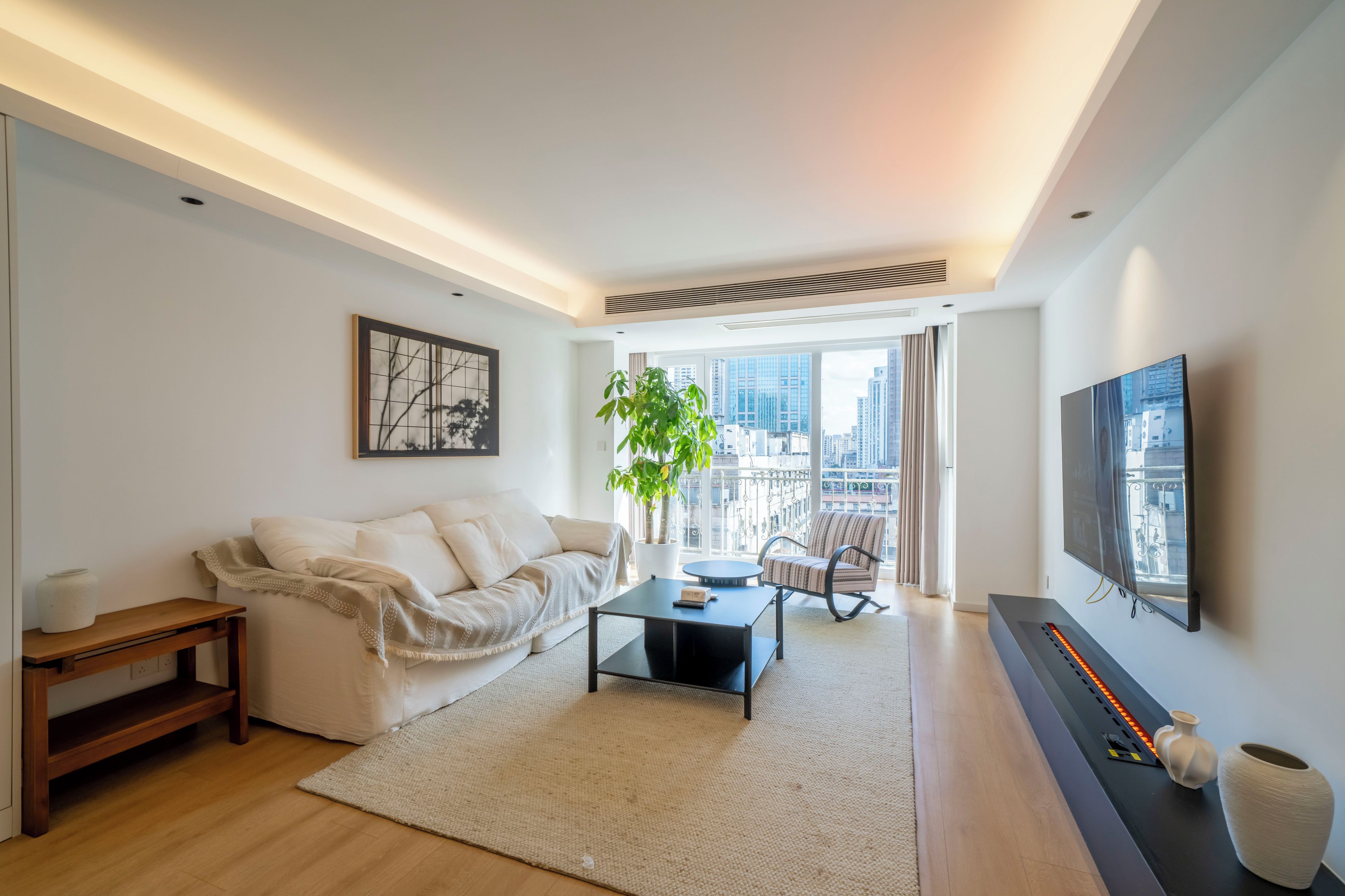 A modern living room with a sofa, coffee table, and a flat-screen TV.