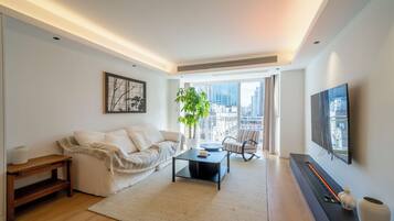 A modern living room with a sofa, coffee table, and a flat-screen TV.