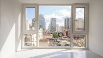 A room with a large window overlooking a cityscape with high-rise buildings.