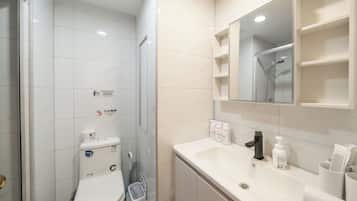Une salle de bain équipée de toilettes, d’une douche et d’un lavabo avec des articles de toilette.