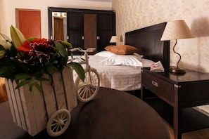 A hotel room with a bed, bedside table, lamp, and a decorative cart with plants. - Complex Mona Caraiman (Poiana Țapului)