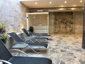 A spa area with reclining chairs, a massage table, and a stone-tiled floor. - Spacious 3-bedroom apartment with AC in charming El Raso (el raso)