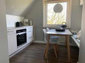 Una cocina compacta con comedor, ventana con vistas y horno empotrado.