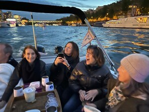 Een groep mensen op een boot met uitzicht op een stadsgezicht en water.