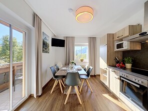 A modern kitchen with wooden cabinets, a built-in microwave, and a large oven. - Edelweiss am See by Interhome (Zell am See)