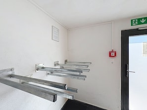 A stairwell with metal handrails, a fire alarm, and an emergency exit sign. - Hochkönig am See by Interhome (Zell am See)
