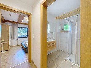 Ein modernes Schlafzimmer mit einem Bett, einem Nachttisch und einem Fenster.