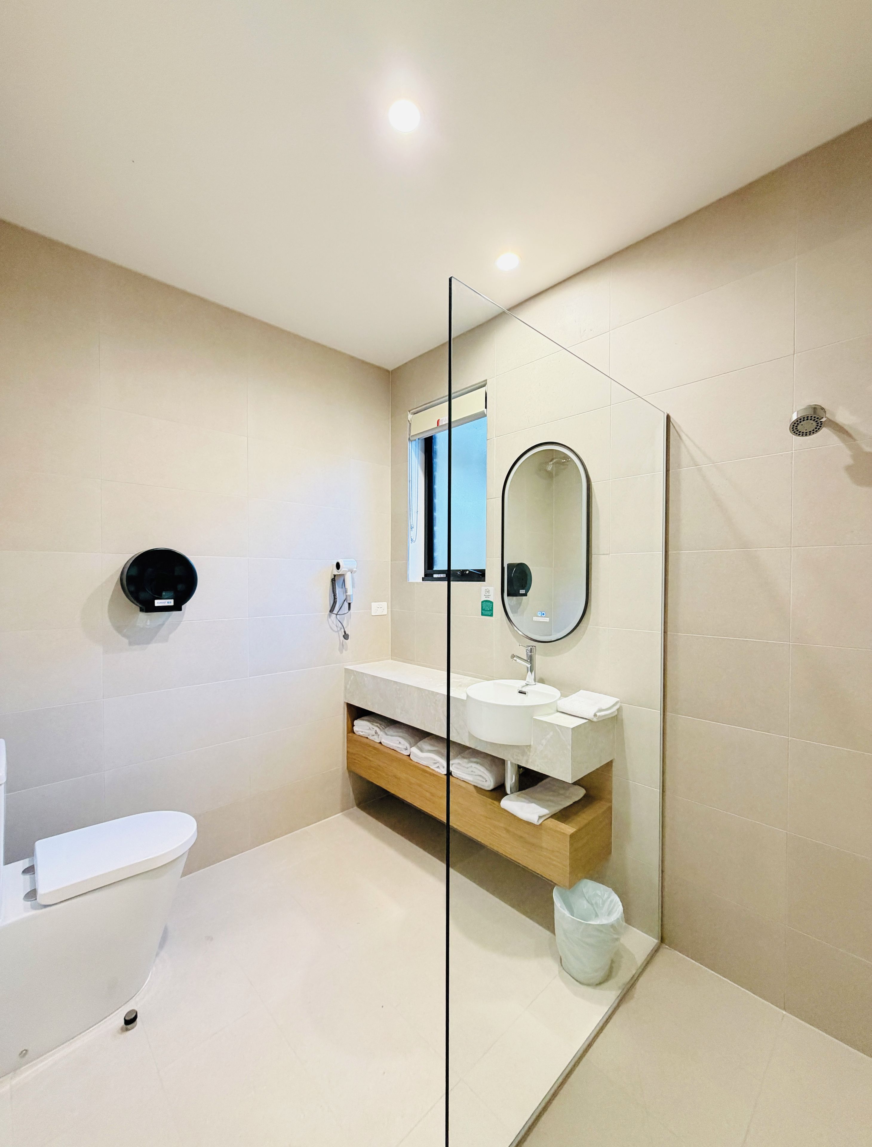 Une salle de bain moderne équipée de toilettes, d’un lavabo et d’un espace douche.