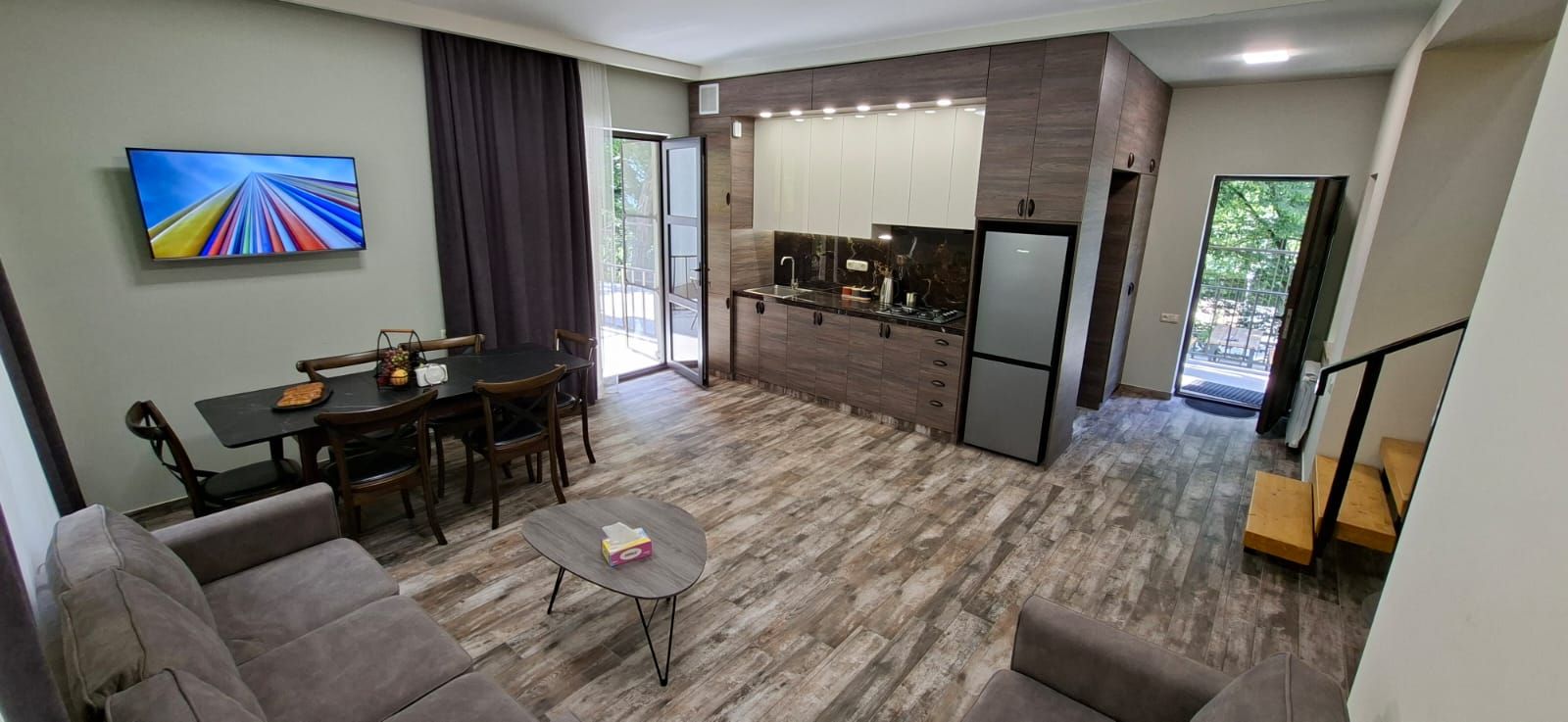 Un espacio moderno para vivir con comedor, cocina y una escalera.