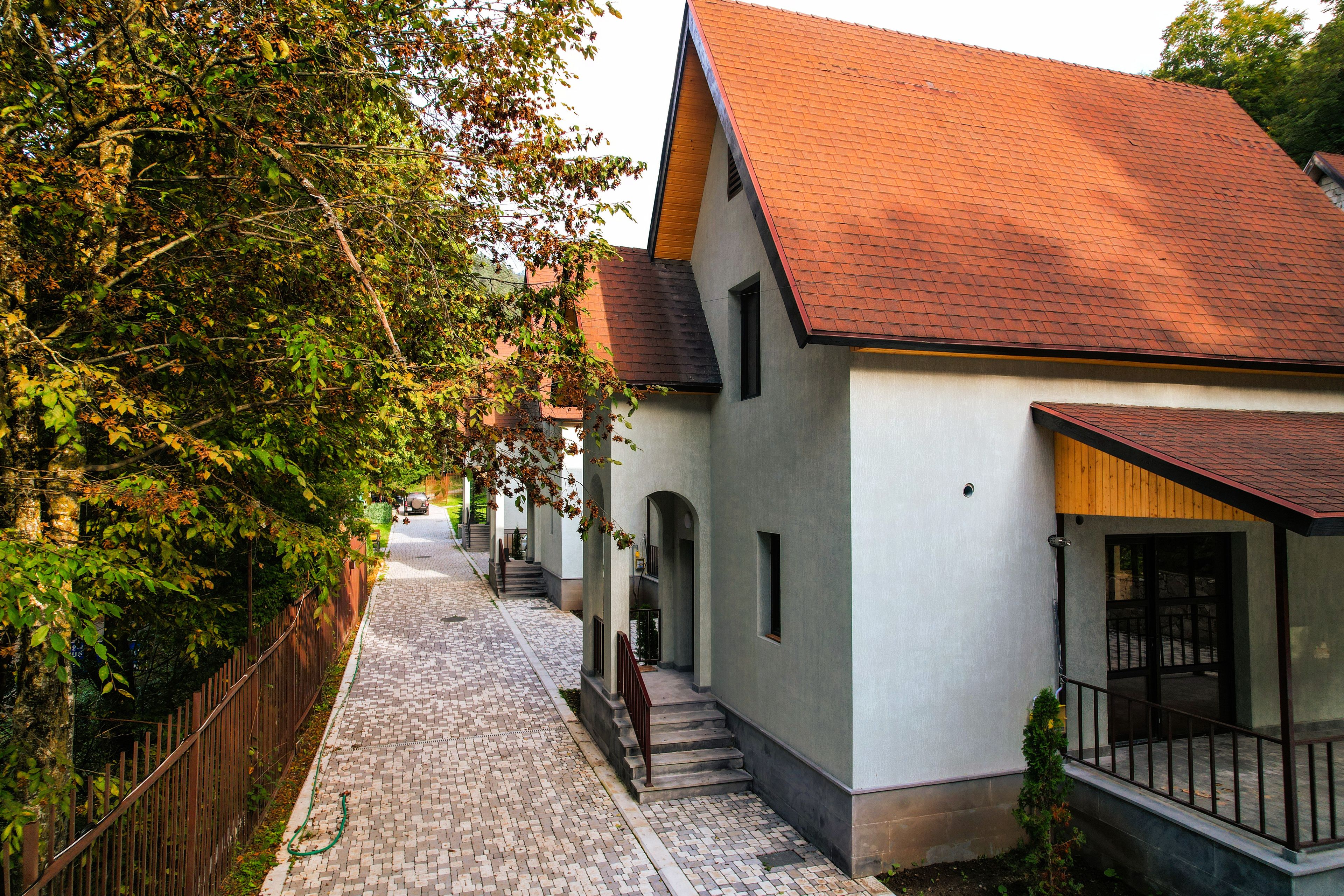 En smal brostensgade kantet af traditionelle huse med røde tegltage og hvide vægge.