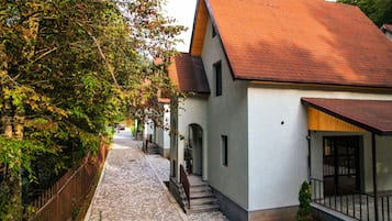 En smal brostensgade kantet af traditionelle huse med røde tegltage og hvide vægge.