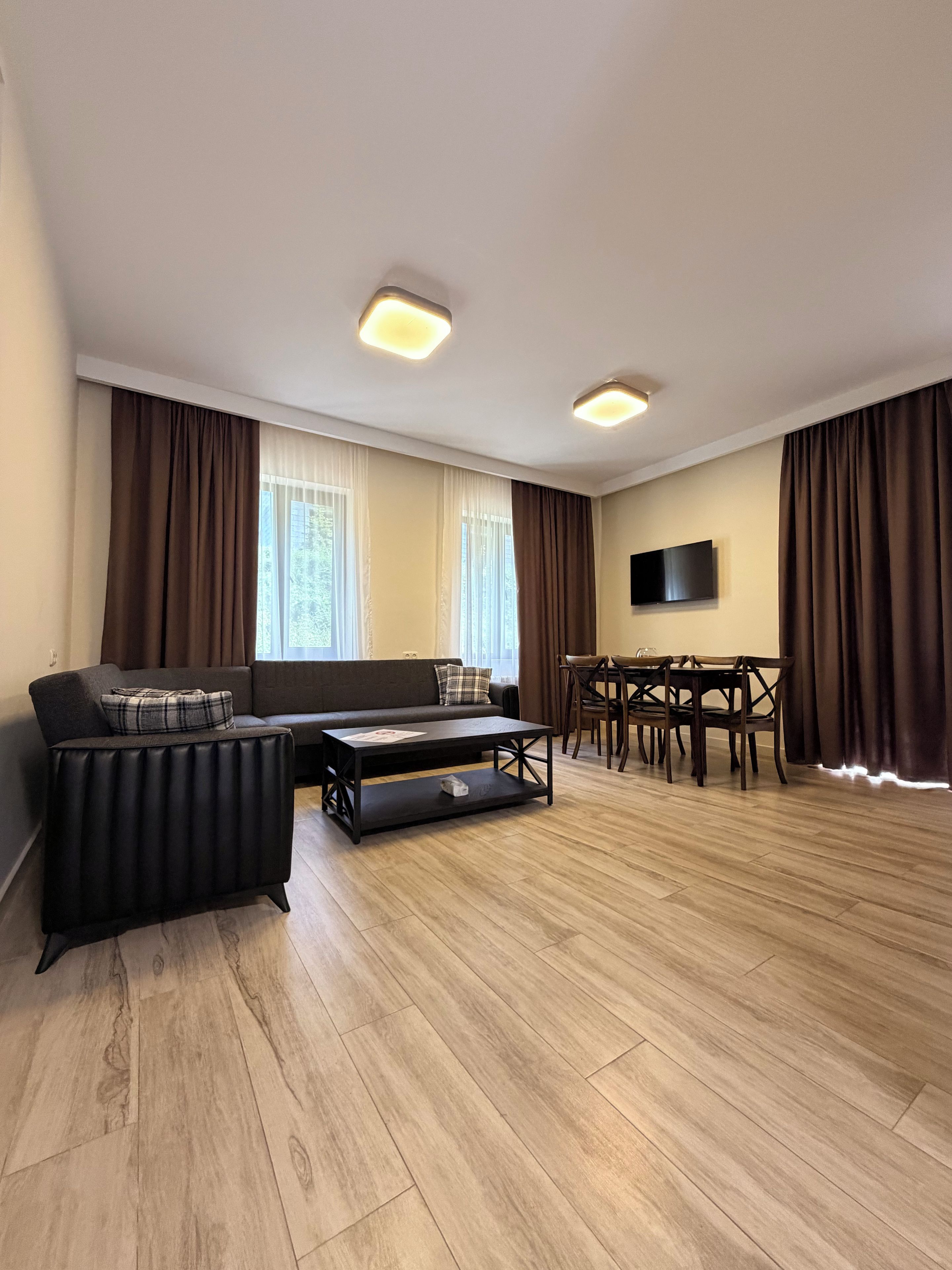 En moderne stue med sofa, sofabord, spisebord og stole.