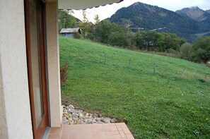 A view of a hillside with a building in the foreground and mountains in the background. - Renovated one-bedroom apartment on the first floor with private parking, 5 minutes from downtown (Châtel)