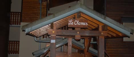 A wooden staircase with a sign reading 'Le Chamoi' and a number '813' on a metal plate.