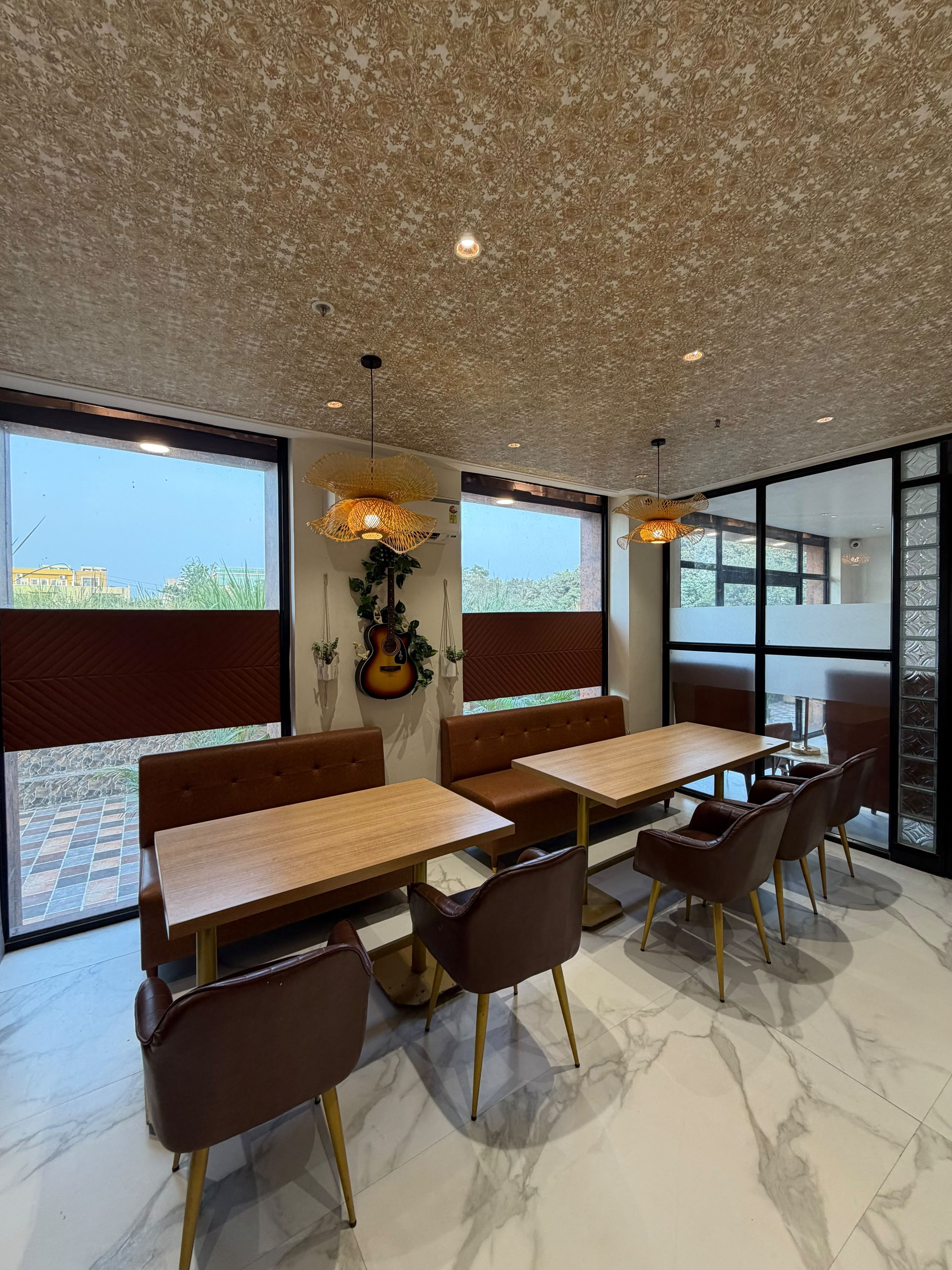 Un comedor moderno con una mesa de madera y sillas de cuero, ventanas amplias y un techo con textura.