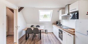 Una cuina petita amb zona de menjador, una finestra i vista a l'exterior.
