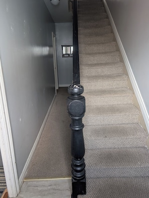A carpeted staircase with a black balustrade. - Gilbert Getaway | Charming 2-Bedroom 2-Bathroom | Downtown St. John’s Retreat 🏡 (St. John's)