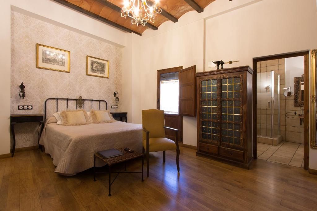 Un dormitorio con cama, una silla, un armario y un espejo.