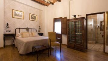 Un dormitorio con cama, una silla, un armario y un espejo.