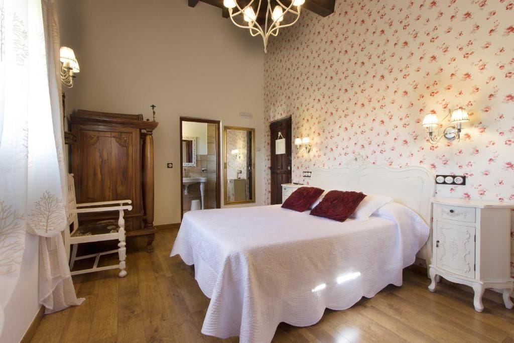 Une chambre à coucher avec un lit, une table de chevet, une commode et un miroir.