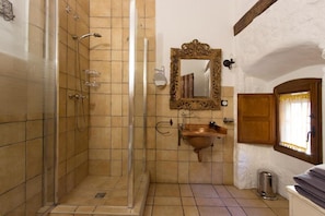 Un bagno con doccia, lavabo e specchio.