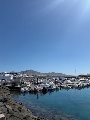 A marina with boats docked, rocky shoreline, and a clear sky. - Villa la Hoya: Private Heated Pool and Sunsets (La Hoya)