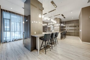 Decoração moderna com área de bar, assentos e iluminação pendente.