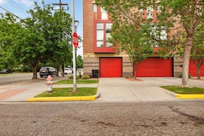 A street view with a fire hydrant, a stop sign, and a red garage door of a building. - Rick's Chill Pad for 4 - Chic Downtown Billings Retreat (Billings)