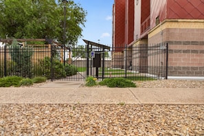 A gated entrance with a pathway leading to a building with a red roof. - Rick's Chill Pad for 4 - Chic Downtown Billings Retreat (Billings)