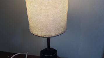 A table lamp with a woven shade on a wooden surface.