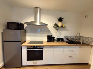 A compact kitchen with a built-in microwave, oven, and a stainless steel range hood. - An ideal getaway for couples or families, just 10 minutes from Cassis. (Carnoux-en-Provence)