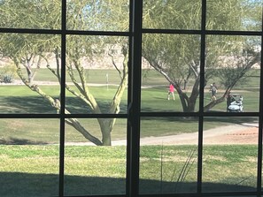A view through a window of a golf course with trees and a golf cart. - Quiet Scottsdale location for Snowbirds - near golf, restaurants and more. (Scottsdale)