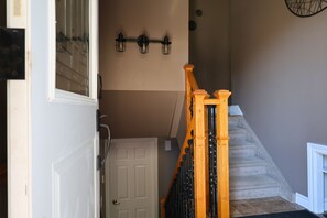 A staircase with wooden balusters and a white door at the bottom. - Melrose Heights | 4BR Executive Home (Timmins)