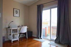 A room with a desk, chair, and a view through a sliding glass door. - Melrose Heights | 4BR Executive Home (Timmins)
