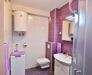 A modern bathroom with a toilet, sink, and shower area. - Cozy 1-bedroom apartment in Dubrovnik with AC, and private parking place (Dubrovnik)