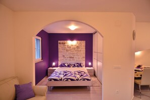 Una camera da letto con un letto, un comodino, una sveglia a parete e una finestra.