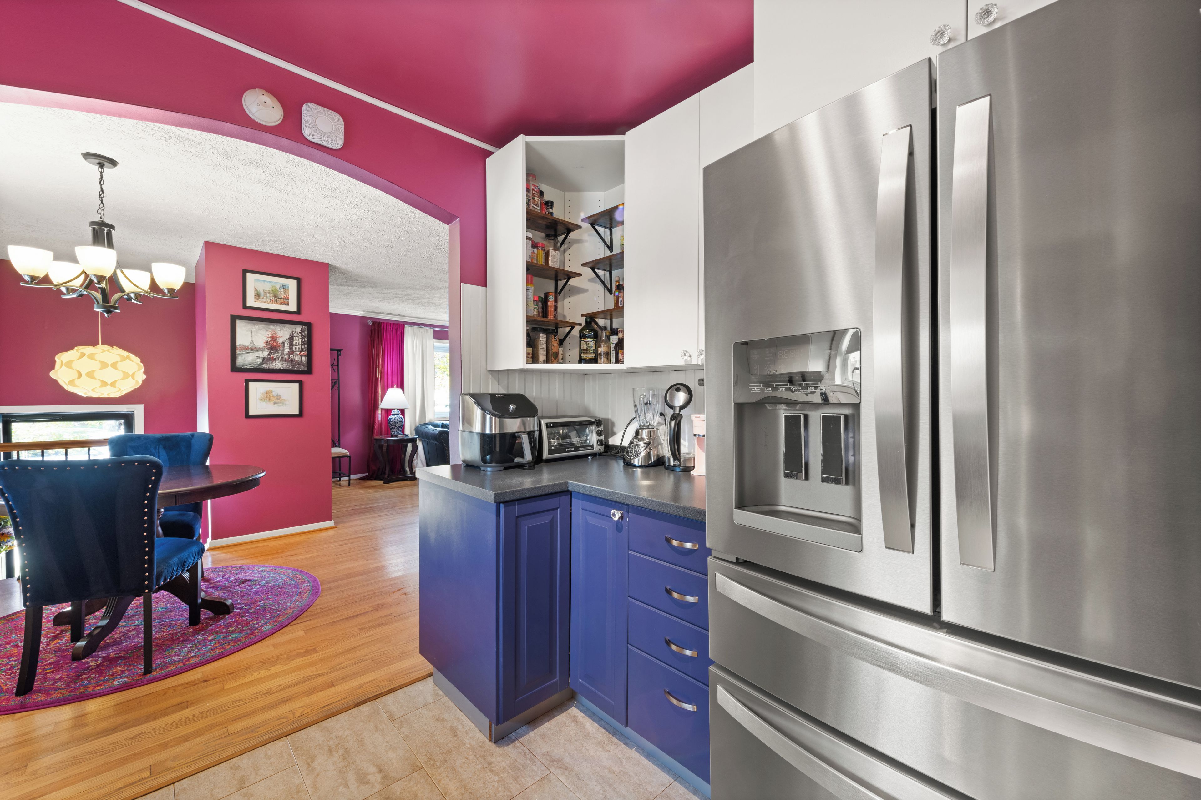 A modern kitchen with a stainless steel refrigerator, a built-in oven, and a coffee maker.