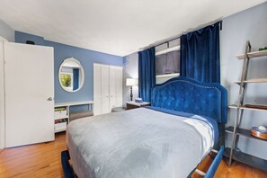 A bedroom with a bed, a wardrobe, a mirror, a window with curtains, and a bedside table. - Pink Paradise in Silver Spring Suburbs (Silver Spring)