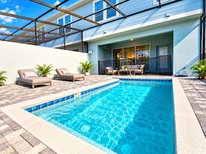 A swimming pool with lounge chairs and a patio area. - Windsor Island 5BR with Pool & Waterpark (Davenport)