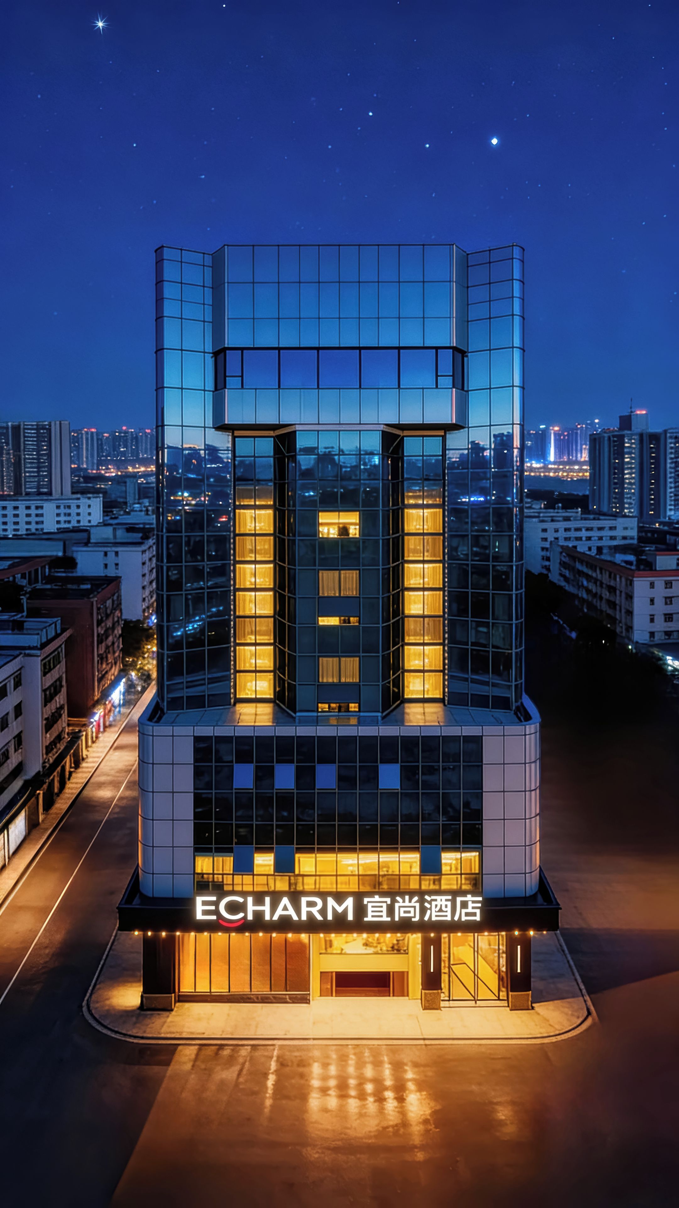 Un hotel moderno con fachada de vidrio, ventanas iluminadas y una entrada destacada.