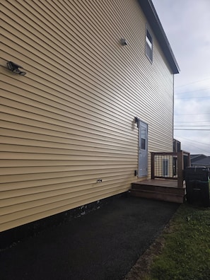 A two-story house with a front porch, a garage, and a small deck.