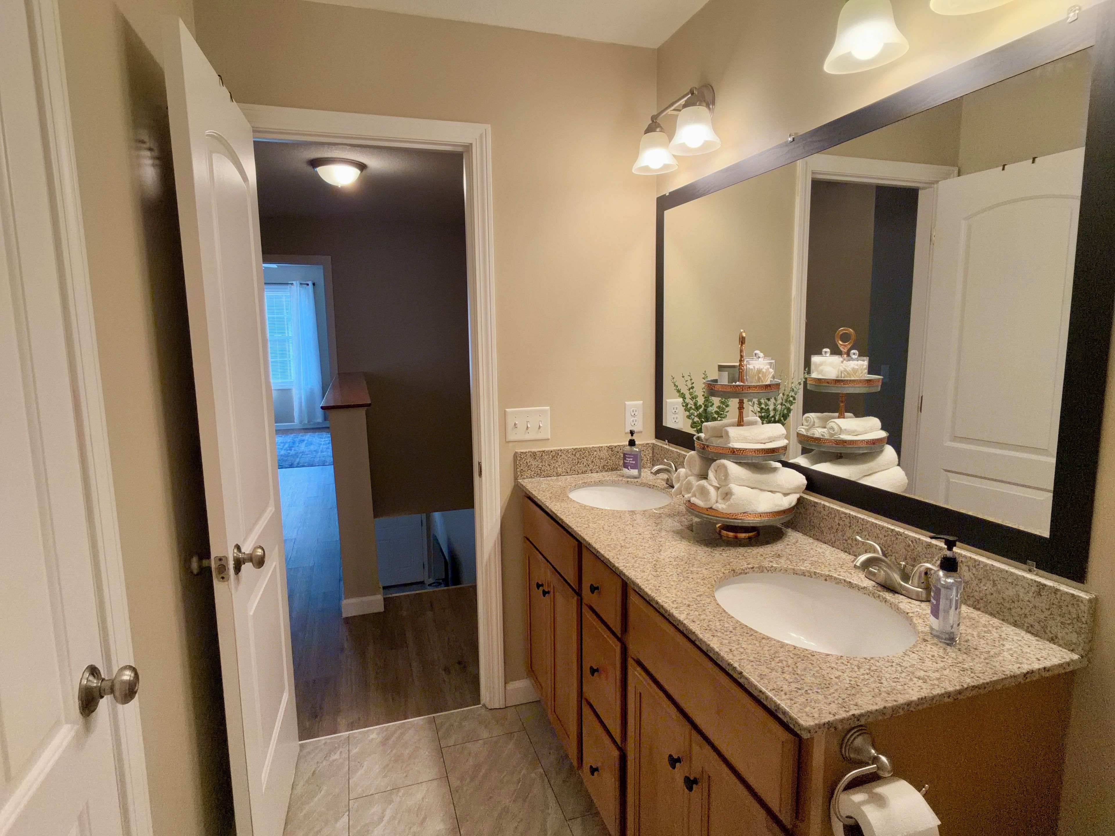 A bathroom with two sinks, a large mirror, and a towel rack.